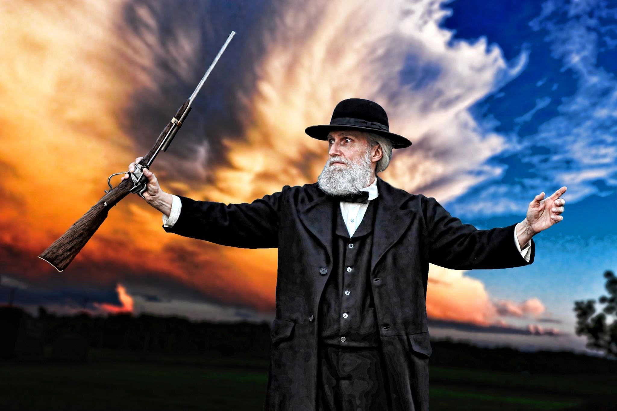 John Brown reenactor against dramatic sky holding rifle